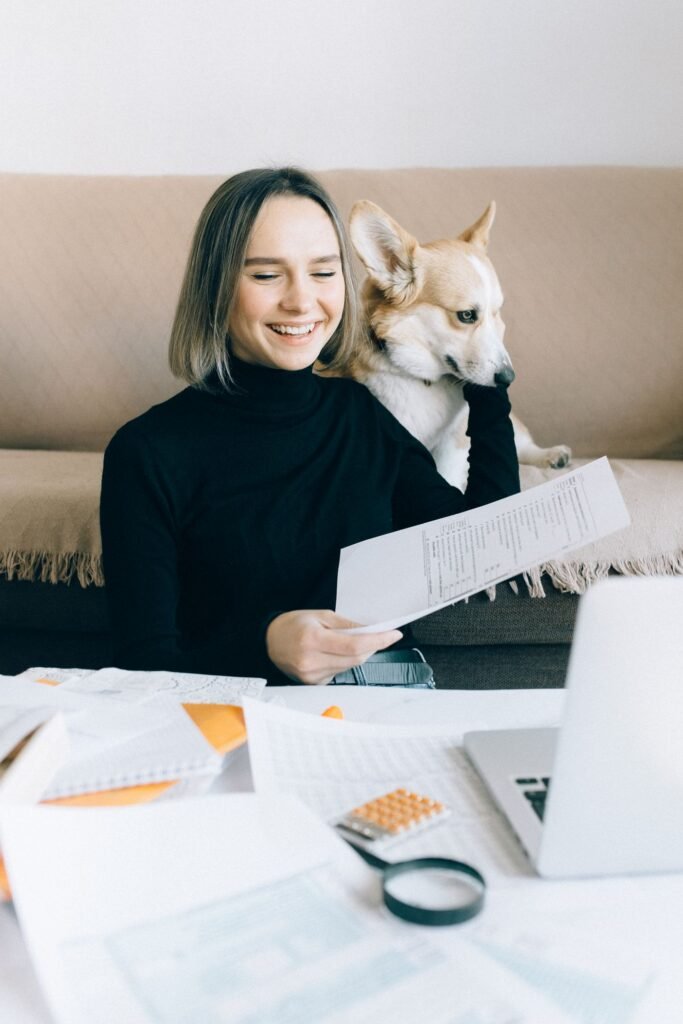 Woman organizing papers with her dog beside her